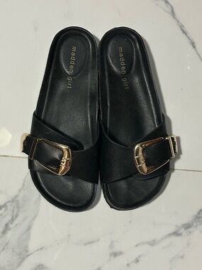 Madden Girl black leather slides with gold heart accents on buckle